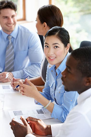 A group of business people sitting around a table in a meeting.